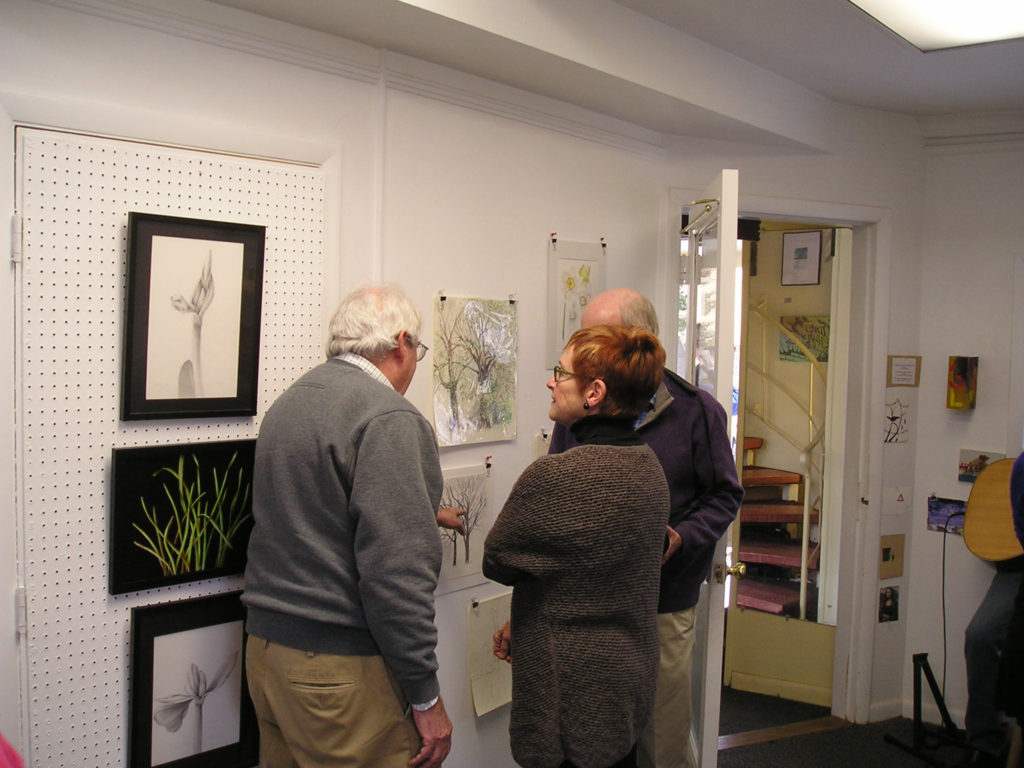 Michael telling fellow Studio 155 artist Vicki Malone about his drawings of the elm trees.